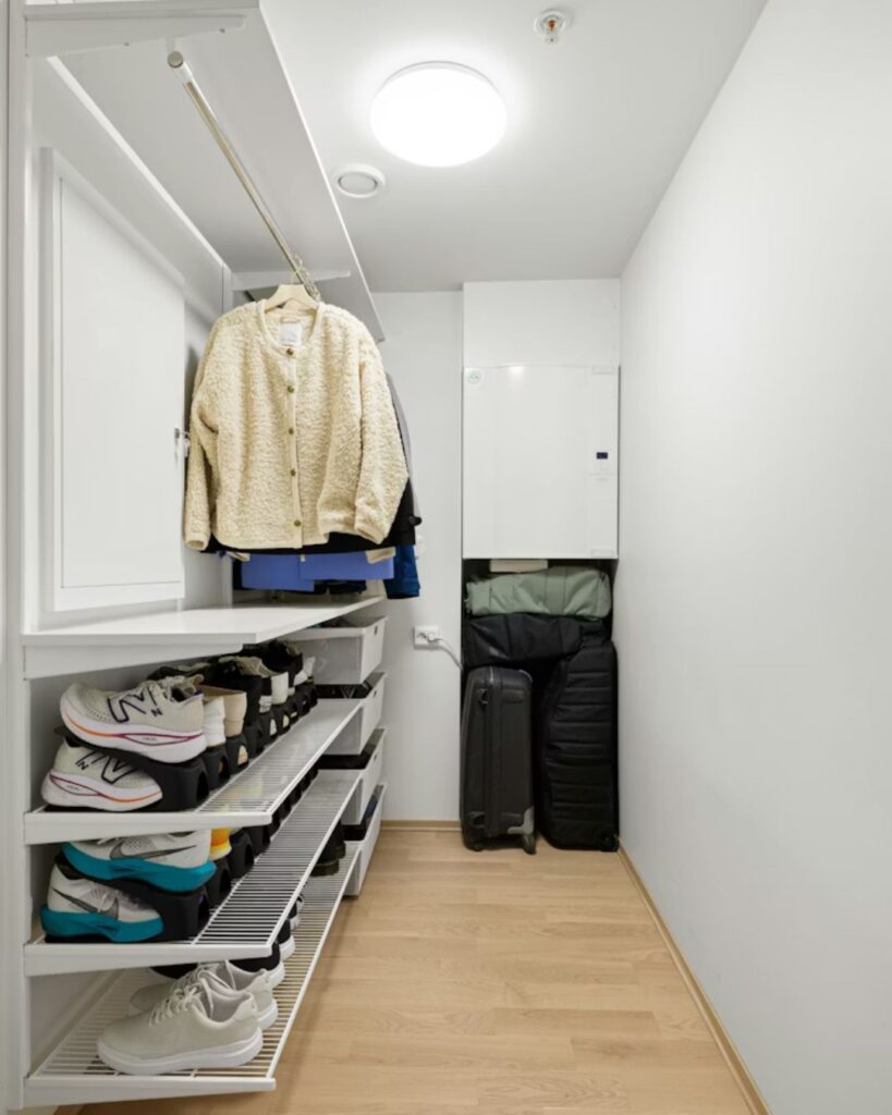Vertical wall shelving storage in small studio apartment